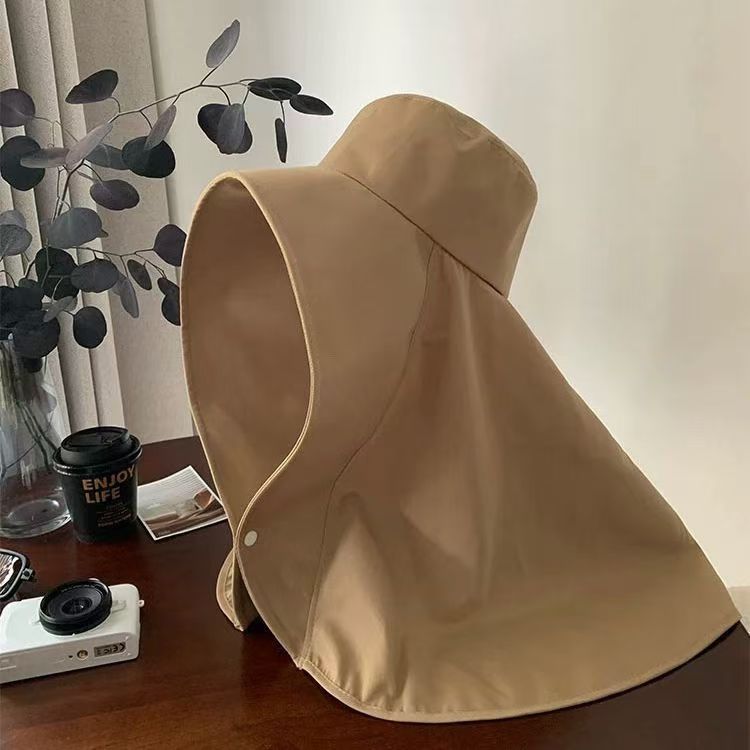 顔全体を包みこむ大きなつば広の帽子